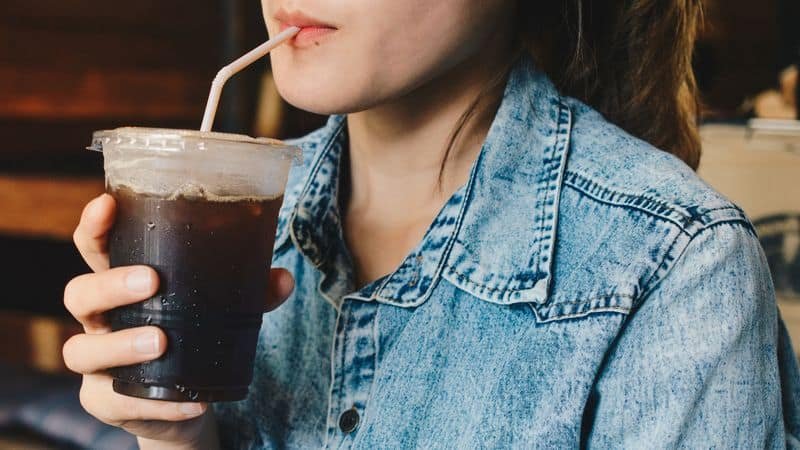 Mujer tomando café negro helado